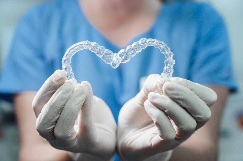 Doreen Dental Clinic team member holding clear aligners